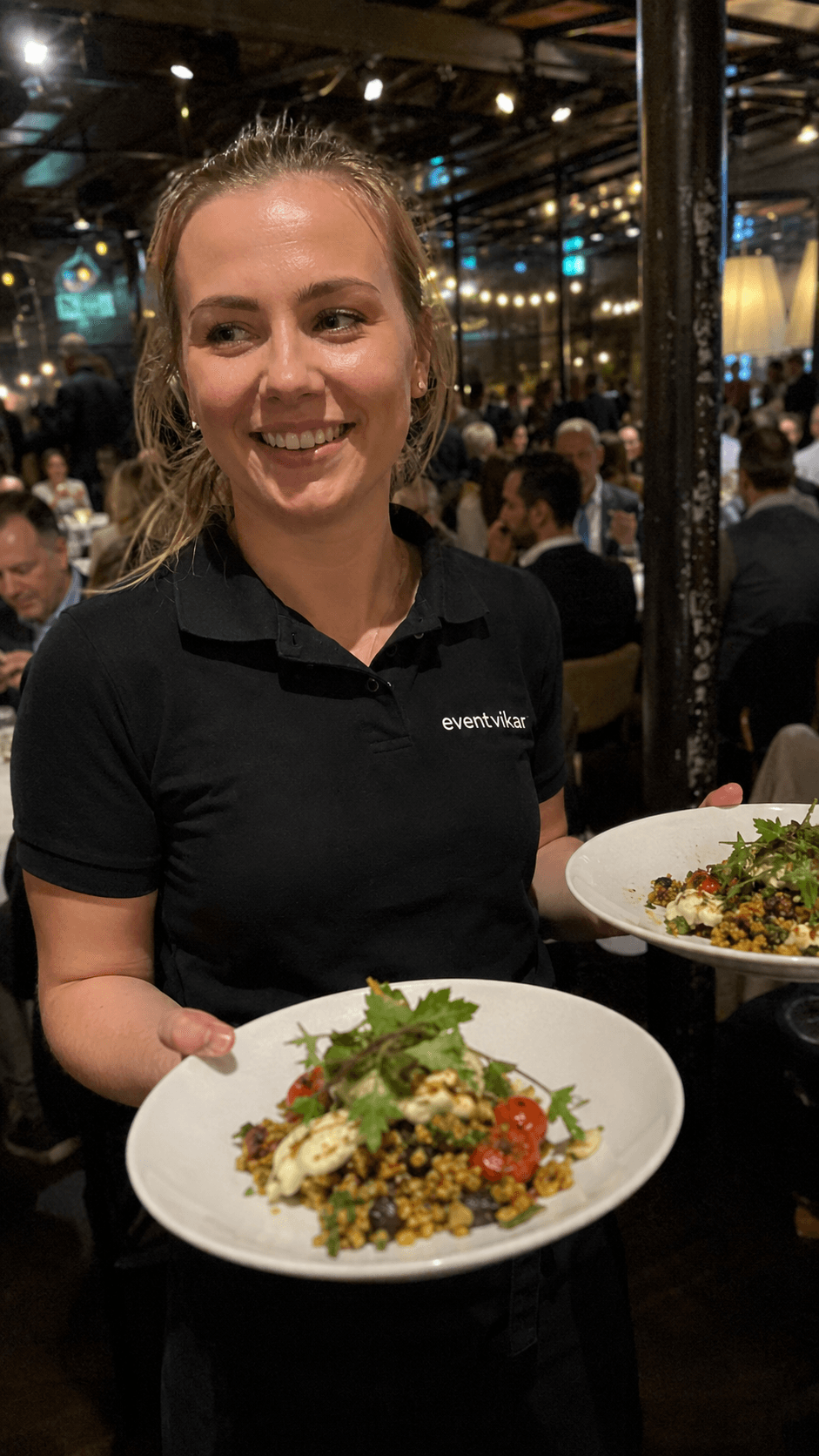 Tjener serverer tallerkener til event