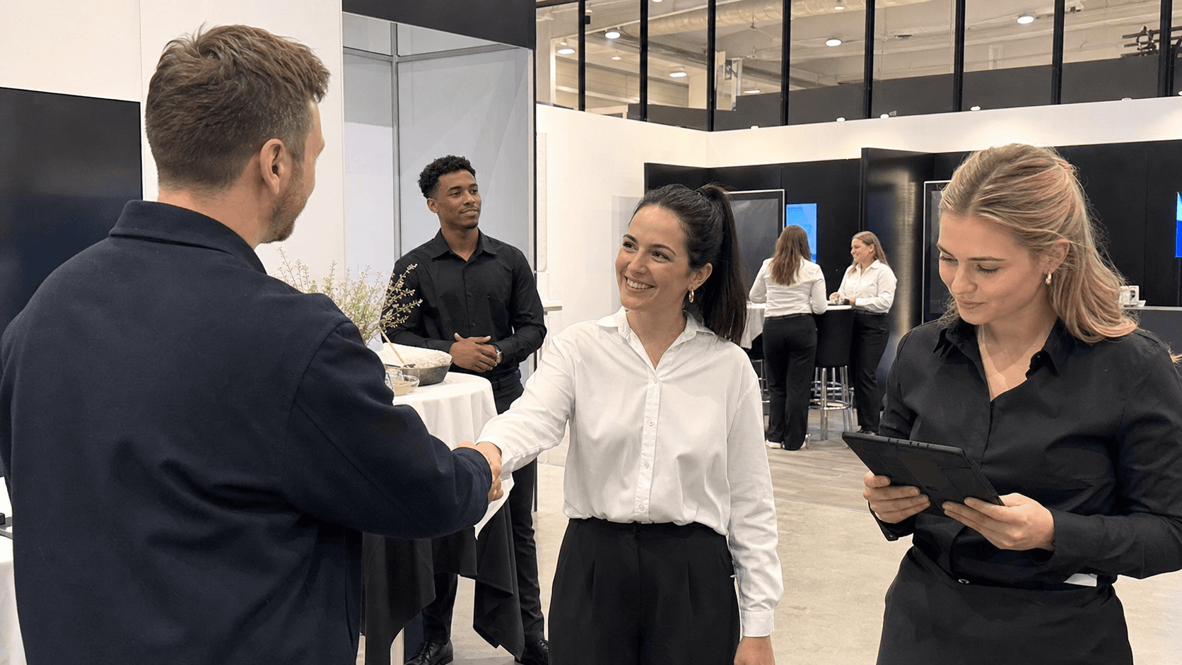 Messe personale hjælper gæster ved en stand
