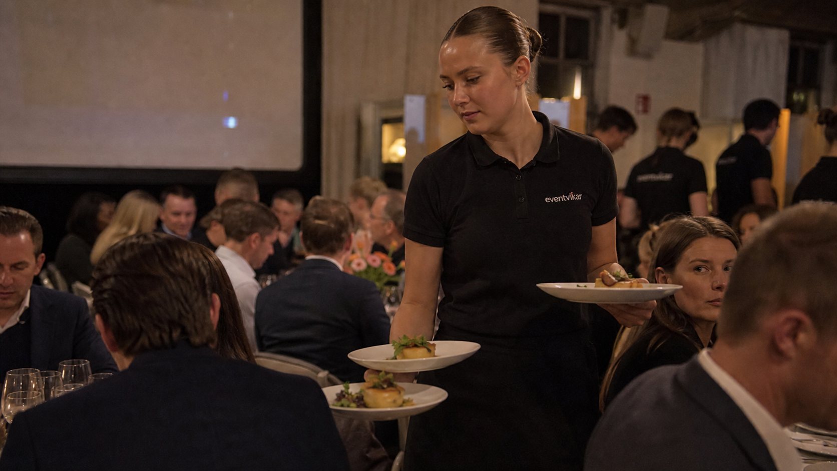 Eventvikar serveringspersonale bærer tallerkener